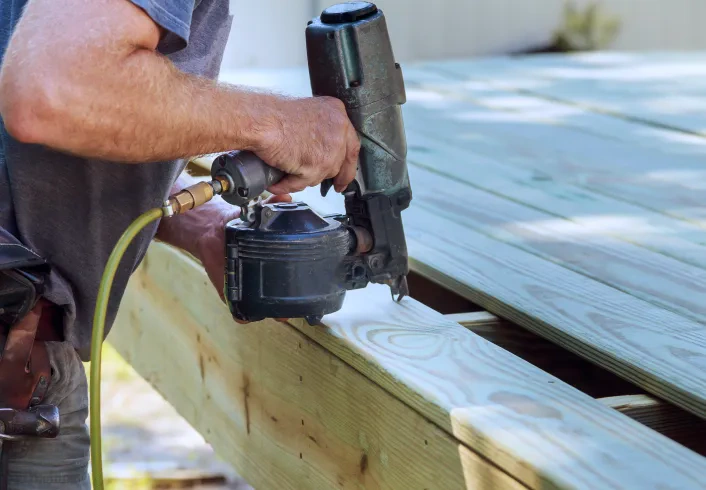 man installing wood planks outdoor deck osage beach mo