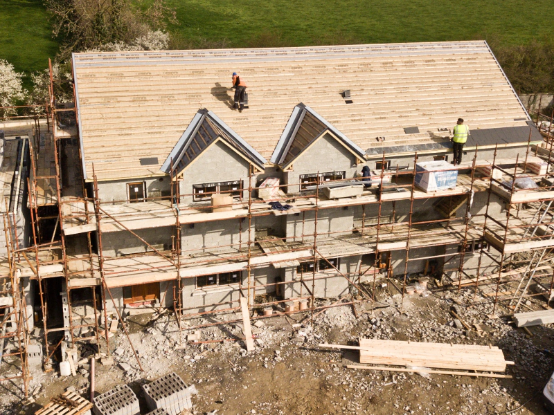 big house being constructed with a wood roofing