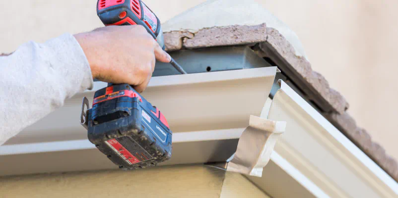 close up shot worker installing seamless gutter